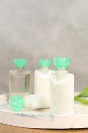 Mini bottles of cosmetic products on table, closeup