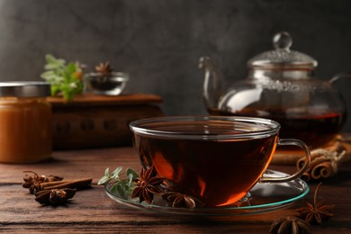 Photo of Aromatic tea with anise stars and mint on wooden table. Space for text