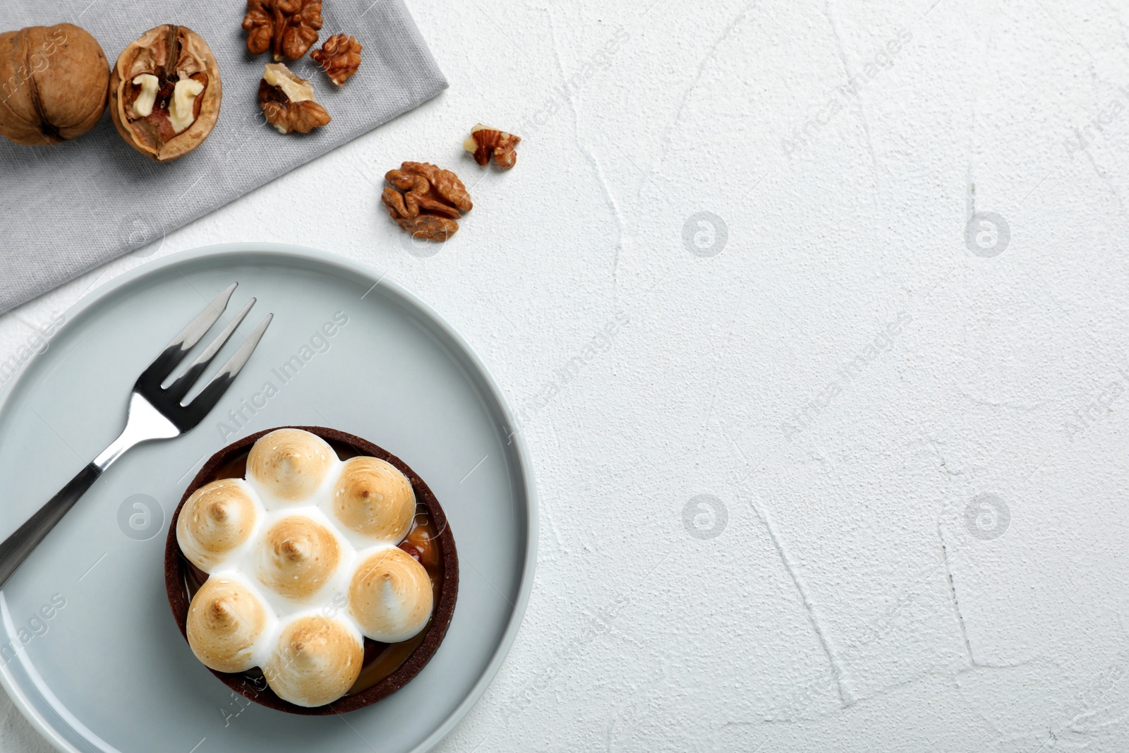 Photo of Delicious salted caramel chocolate tart with meringue served on light table, flat lay. Space for text