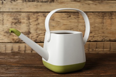 Photo of New modern watering can on wooden table