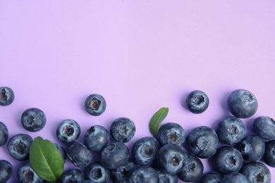 Photo of Fresh ripe blueberries on lilac background, flat lay. Space for text