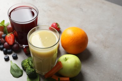 Delicious juices and fresh ingredients on grey table