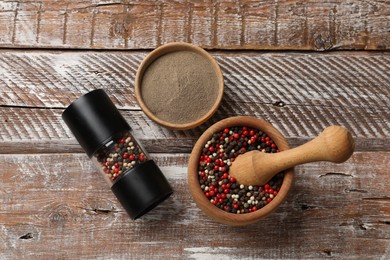 Photo of Ground pepper and grains on wooden table, flat lay