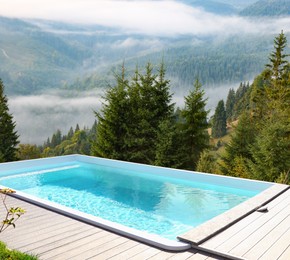 Image of Outdoor swimming pool at luxury resort and beautiful view of mountains on sunny day