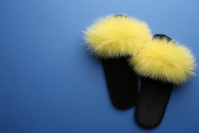 Pair of soft slippers on blue background, flat lay. Space for text