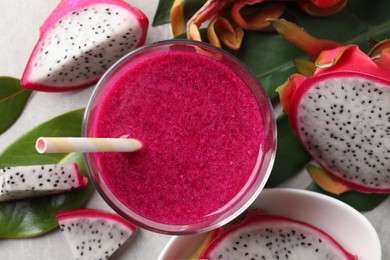 Photo of Delicious pitahaya smoothie and fresh fruits on light grey table, flat lay
