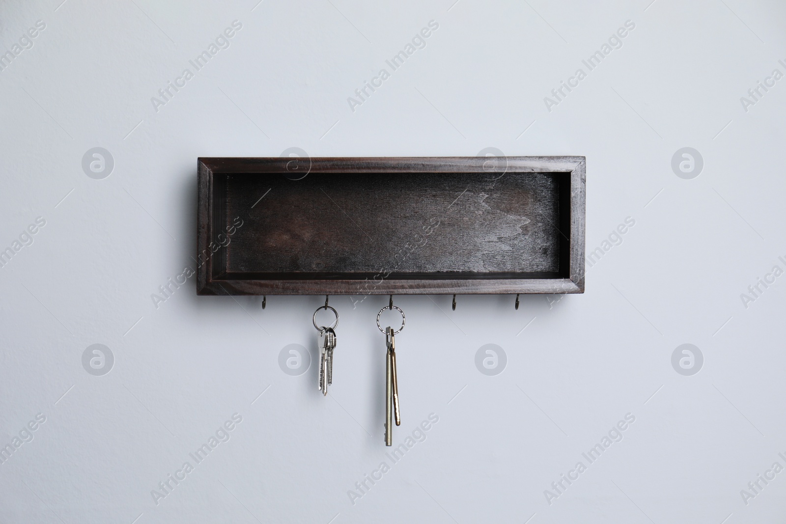 Photo of Wooden hanger for keys on white wall