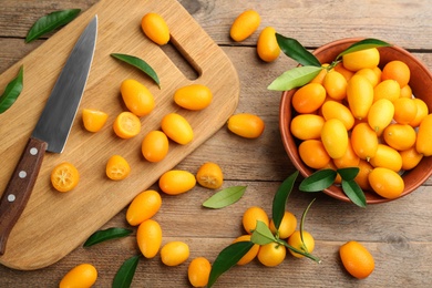 Flat lay composition with fresh ripe kumquats on wooden table