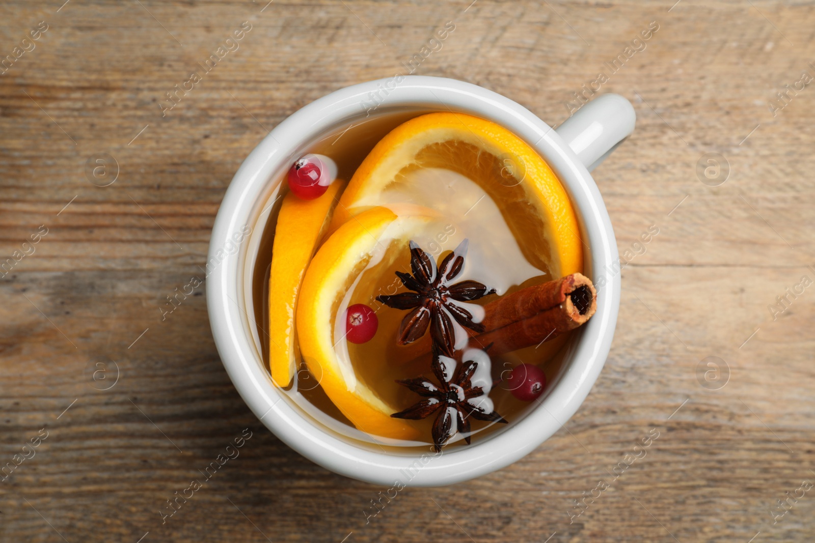 Photo of Aromatic mulled wine on wooden table, top view