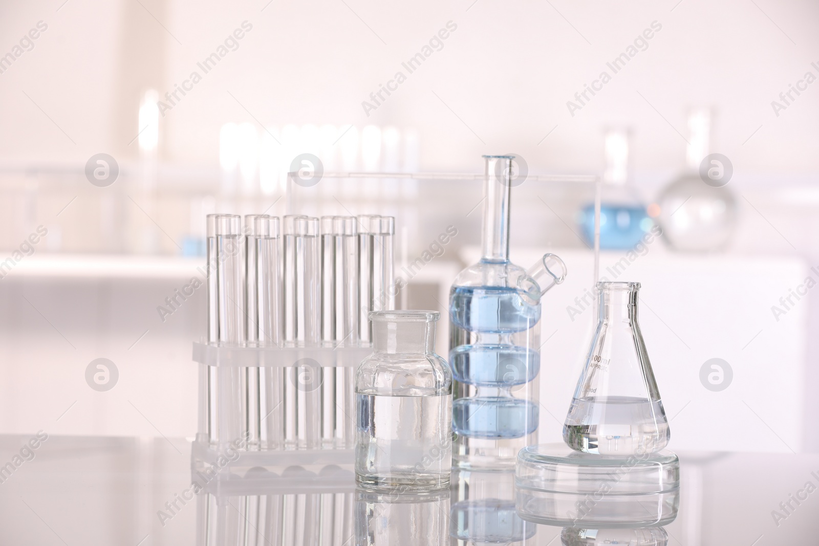 Photo of Laboratory analysis. Different glassware with liquid on white table indoors