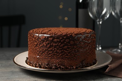 Delicious chocolate truffle cake on grey textured table