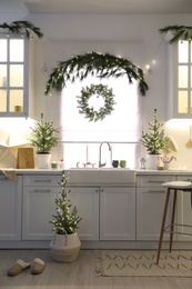 Small Christmas trees and festive decor in kitchen