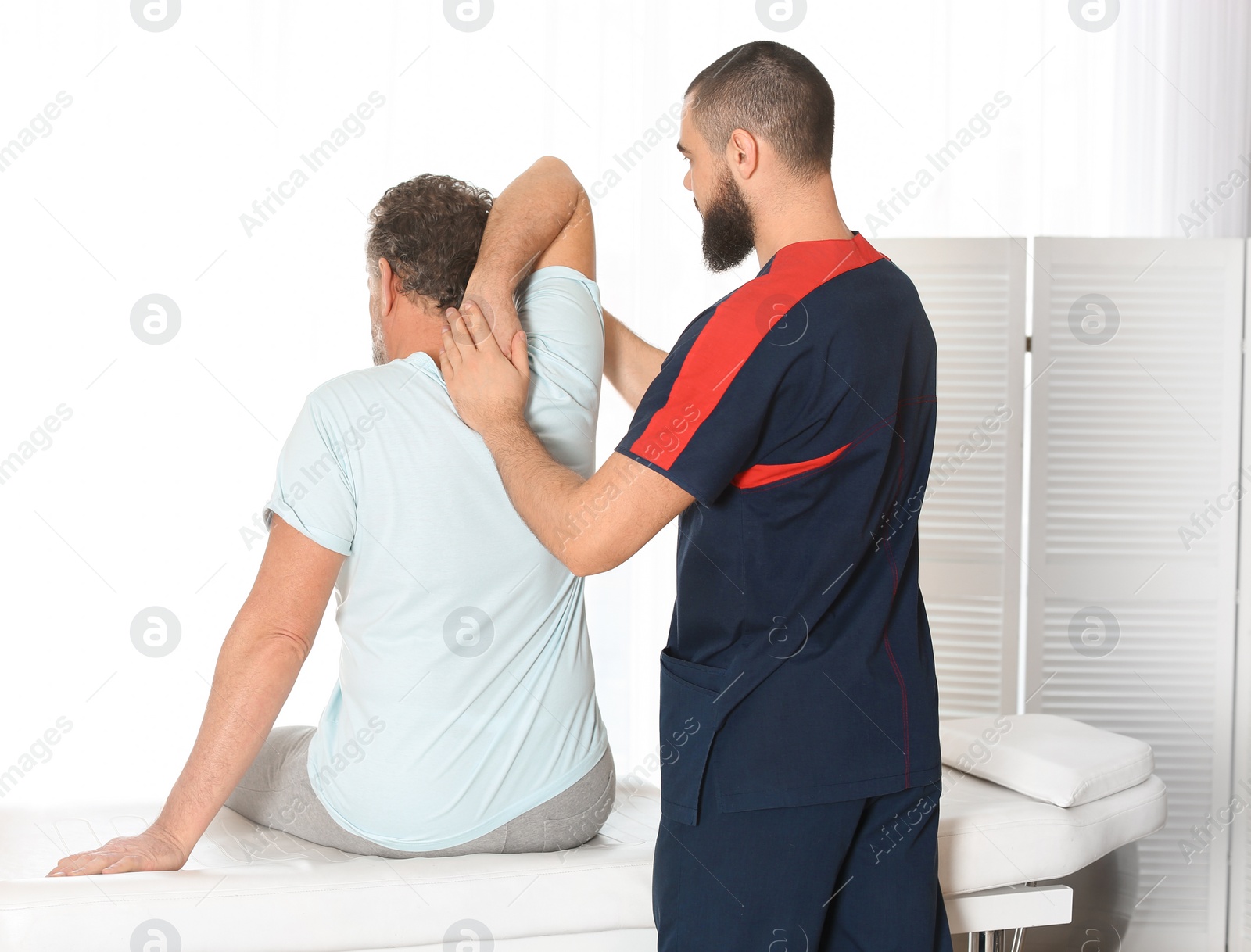 Photo of Physiotherapist working with patient in clinic. Rehabilitation therapy