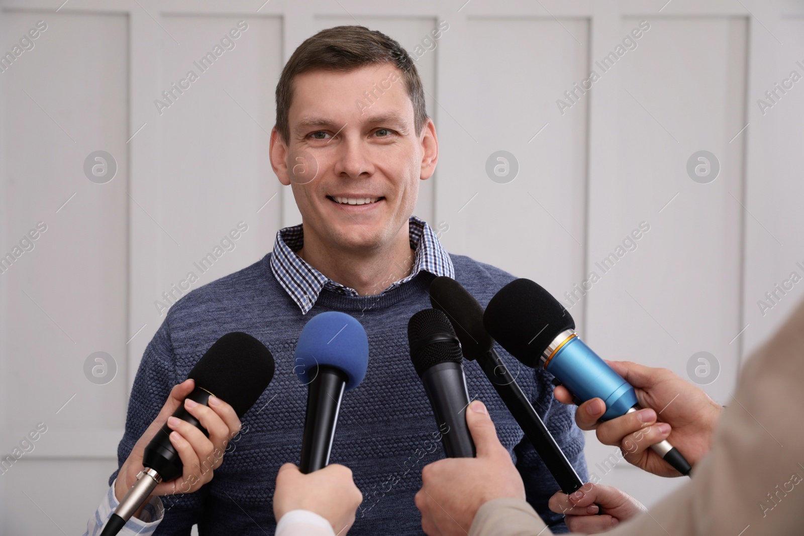 Photo of Happy business man giving interview to journalists at official event