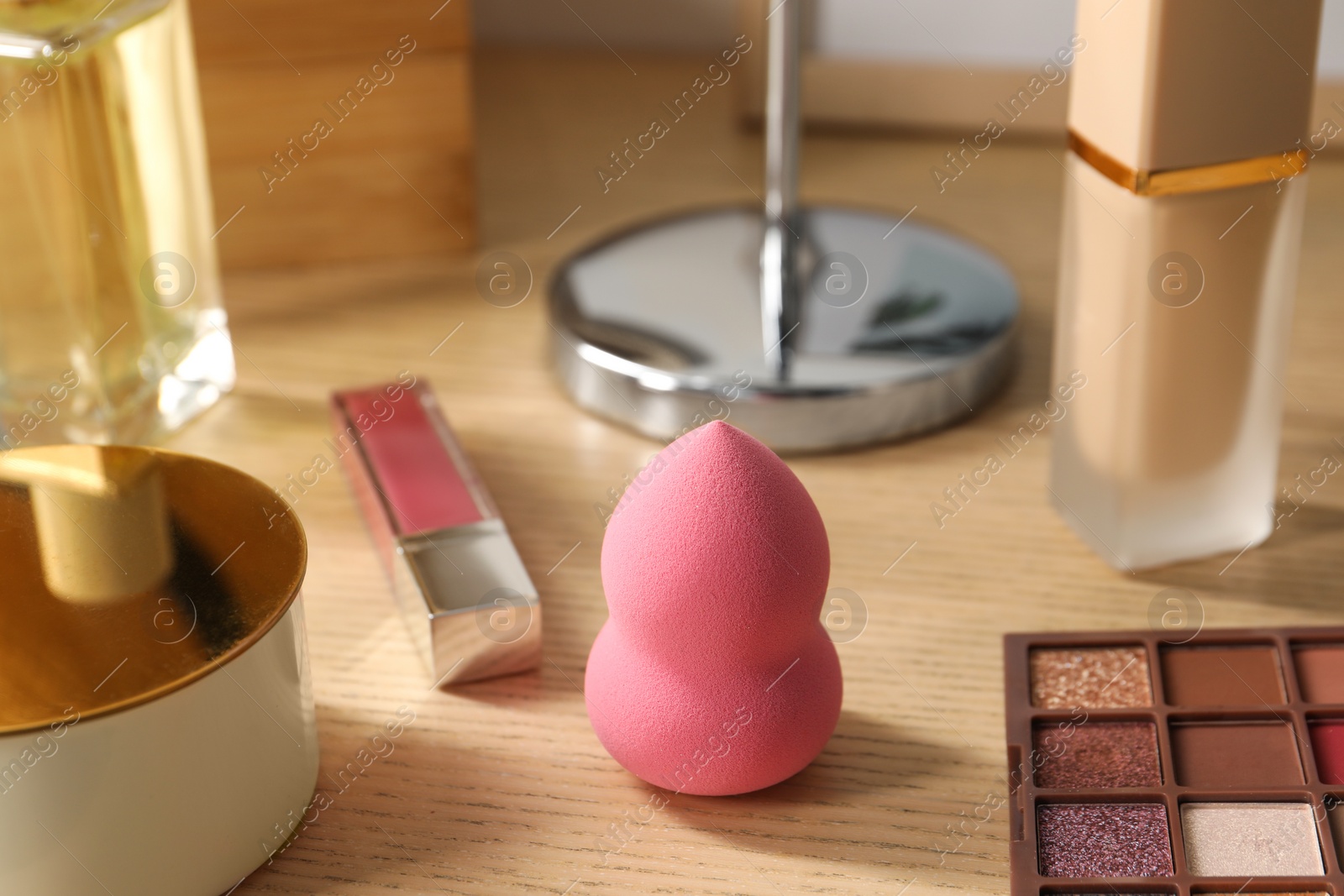 Photo of Makeup products on wooden dressing table, closeup