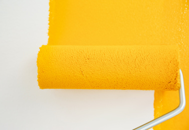 Photo of Painting white wall with yellow dye, closeup. Interior renovation