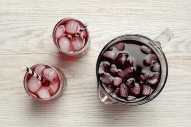 Photo of Delicious iced hibiscus tea on white wooden table, flat lay