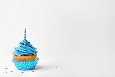 Photo of Birthday cupcake with candle on white background