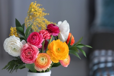 Photo of Vase with beautiful ranunculus flowers indoors