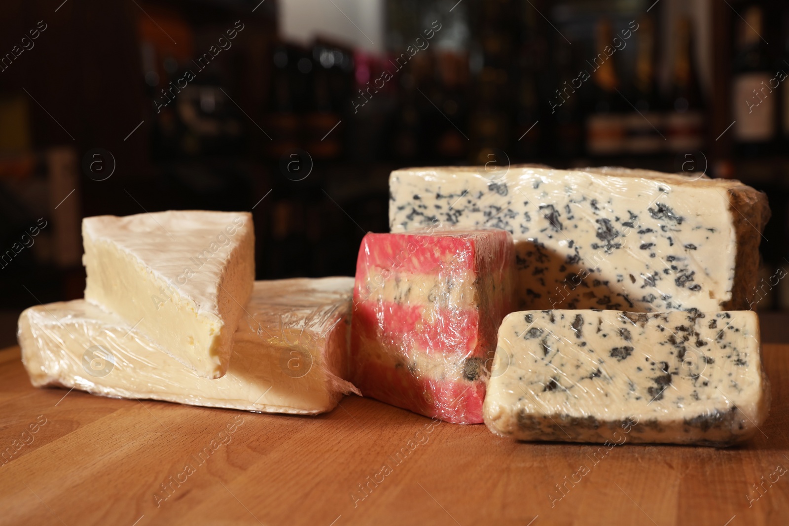 Photo of Different types of delicious cheeses on counter in store