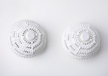 Photo of Dryer balls for washing machine on white table, flat lay