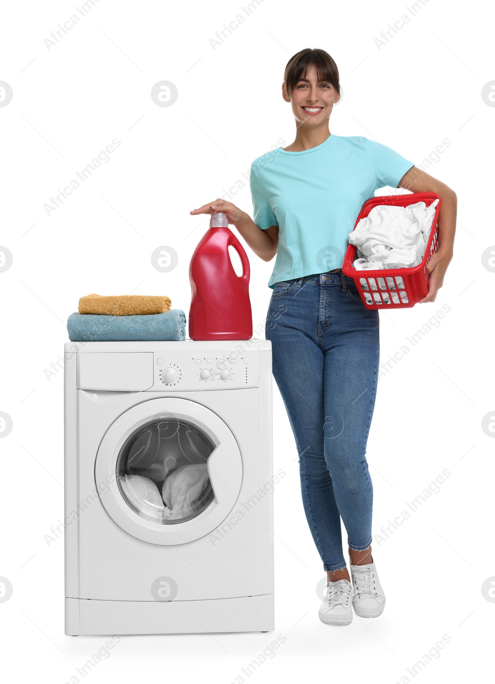 Photo of Beautiful woman with laundry basket and detergent near washing machine against white background