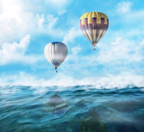 Image of Dream world. Hot air balloons in sky with clouds over misty sea