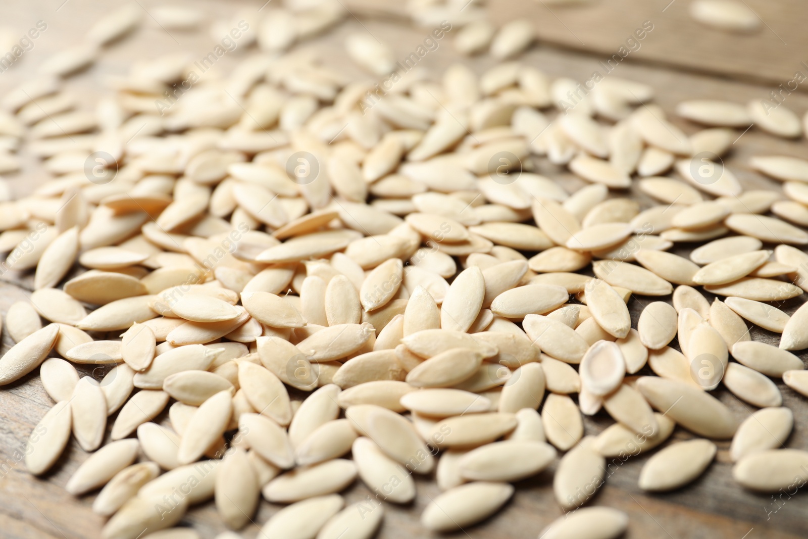 Photo of Raw cucumber seeds on wooden background, closeup. Vegetable planting