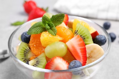Photo of Delicious fresh fruit salad in bowl on table, closeup