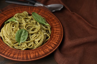 Photo of Tasty pasta with spinach on table, space for text