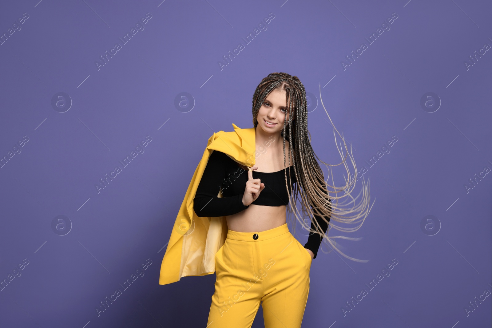 Photo of Beautiful woman with long african braids on purple background, space for text