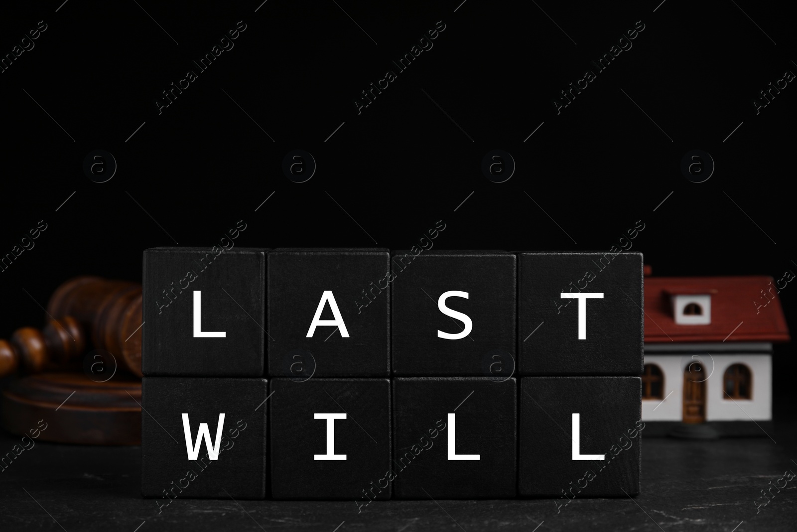 Photo of Black cubes with words Last Will on wooden table against dark background