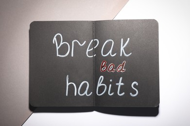 Photo of Open notebook with phrase Break Bad Habits on color background, top view