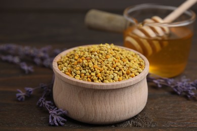 Fresh bee pollen granules in bowl, lavender and honey on wooden table, closeup