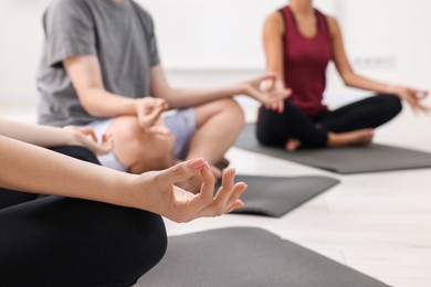Photo of Group of people practicing yoga on mats indoors, closeup. Space for text