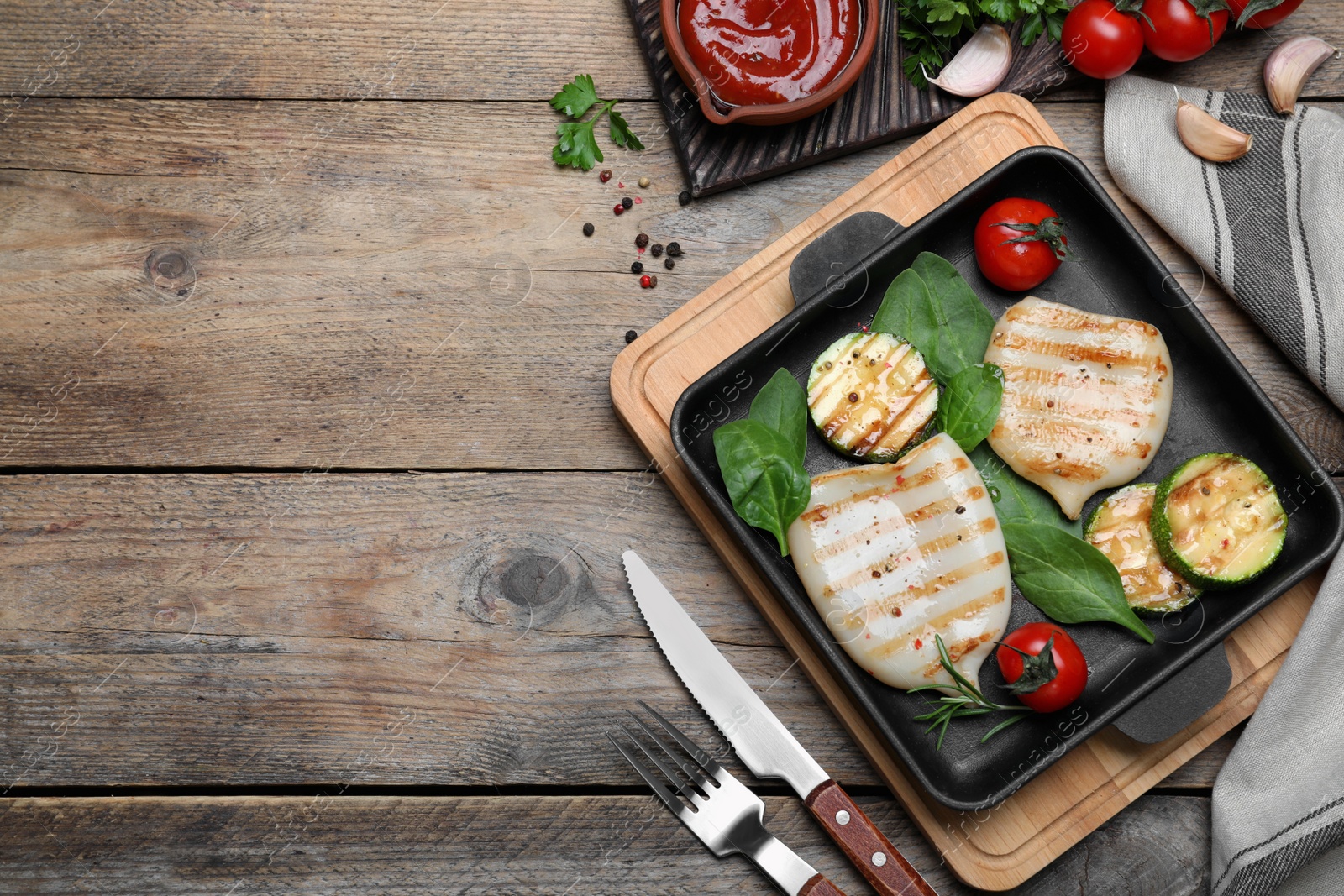 Photo of Grilled squid served on wooden table, flat lay. Space for text