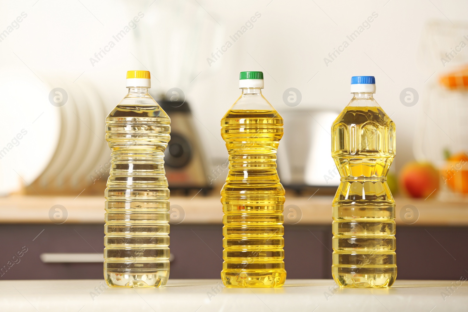 Photo of Bottles of oil on table against blurred background