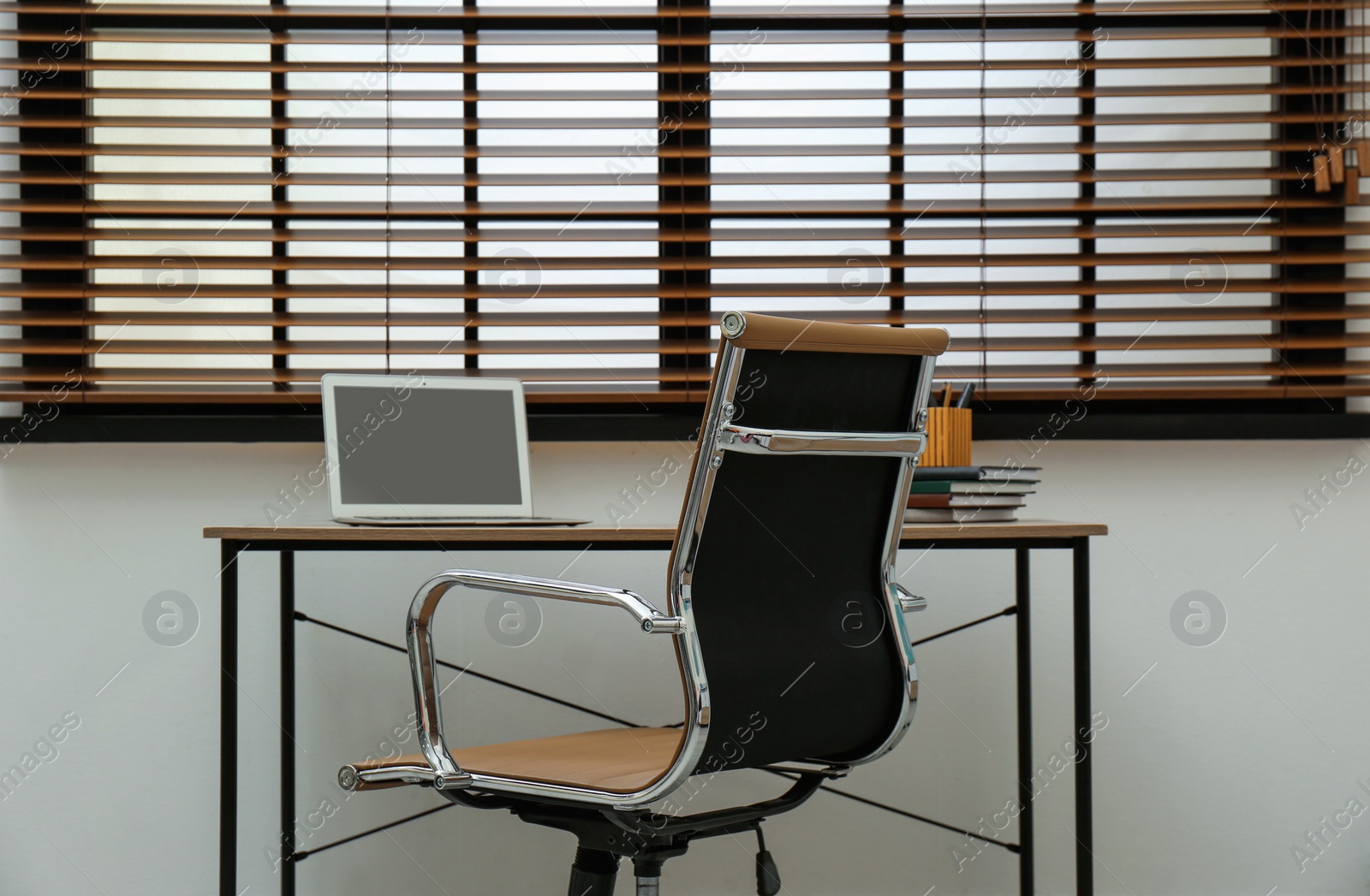 Photo of Stylish workplace interior with modern office chair