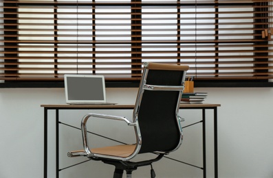 Photo of Stylish workplace interior with modern office chair