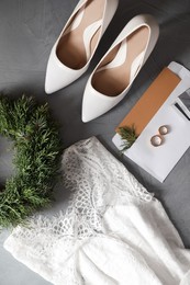 Photo of Flat lay composition with wedding dress, white high heel shoes and rings on grey background