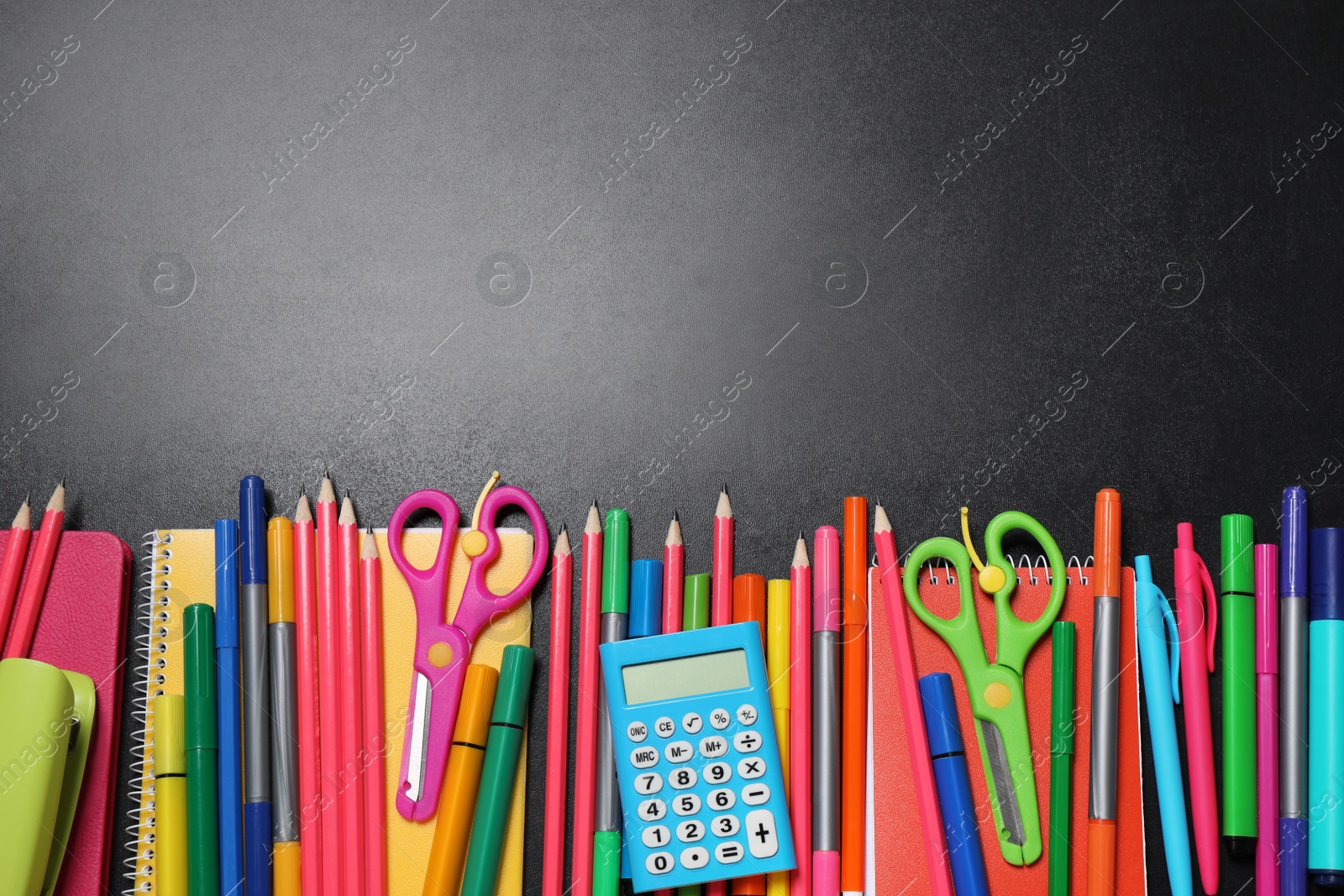 Photo of Flat lay composition with school stationery on black chalkboard, space for text