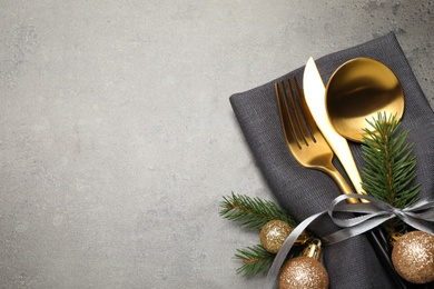 Photo of Cutlery set and Christmas decor on grey table, flat lay. Space for text