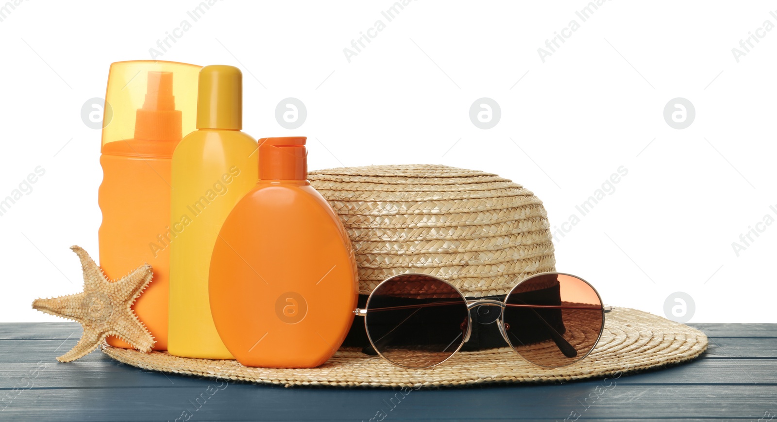Photo of Sun protection products and beach accessories on blue wooden table