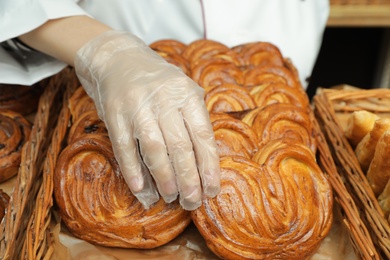 Photo of Baker putting fresh bun onto tray, closeup