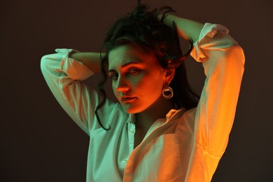 Photo of Portrait of beautiful young woman on color background with neon lights