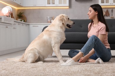 Photo of Woman with cute Labrador Retriever dog on floor at home. Adorable pet