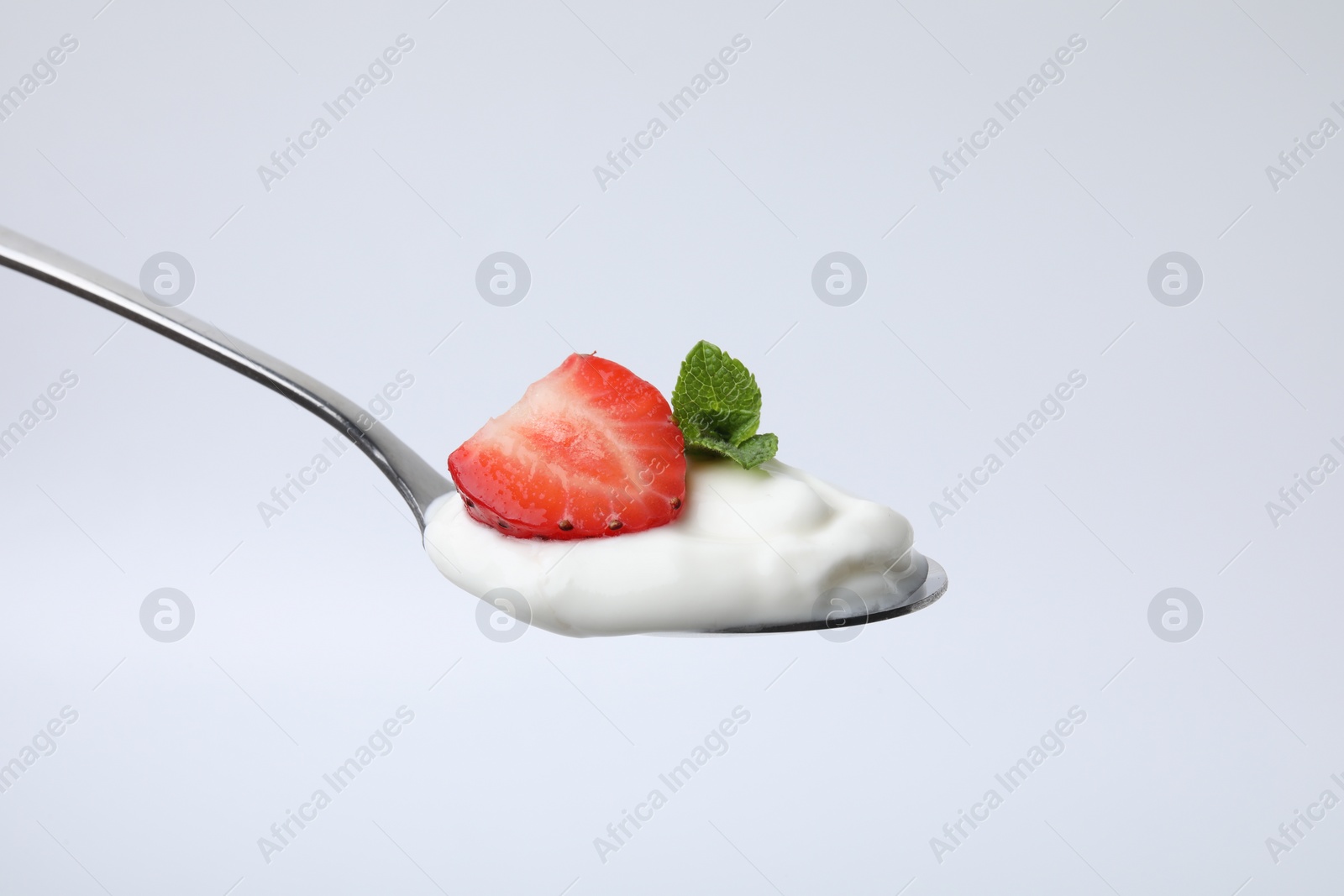 Photo of Spoon with yogurt, strawberry and mint isolated on white