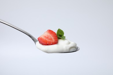 Spoon with yogurt, strawberry and mint isolated on white