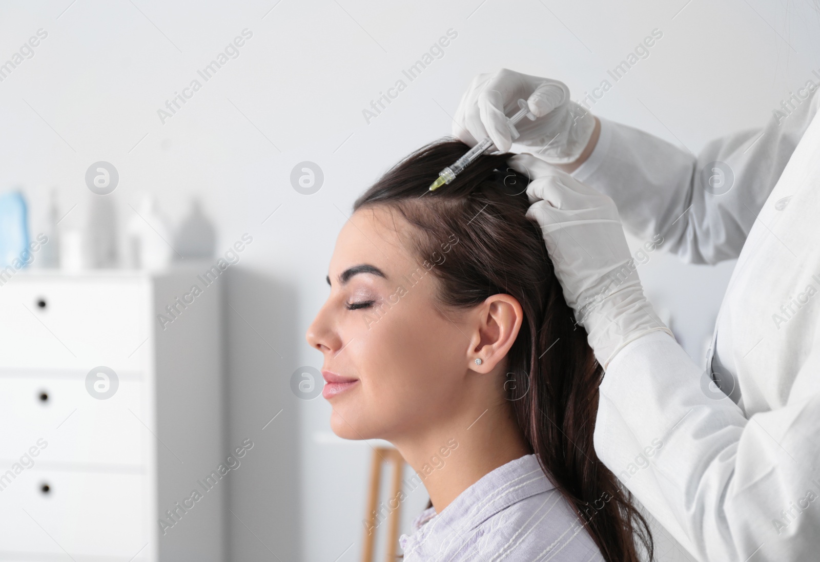 Photo of Young woman with hair loss problem receiving injection in salon