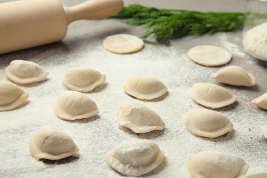 Raw dumplings on grey table, closeup. Process of cooking